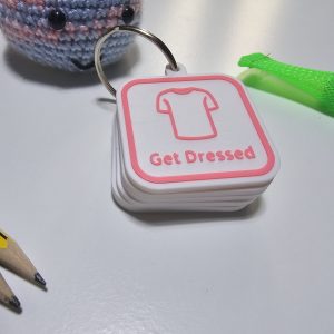 Get Dressed visual routine tag for autism morning routine with custom pink icon and border.
